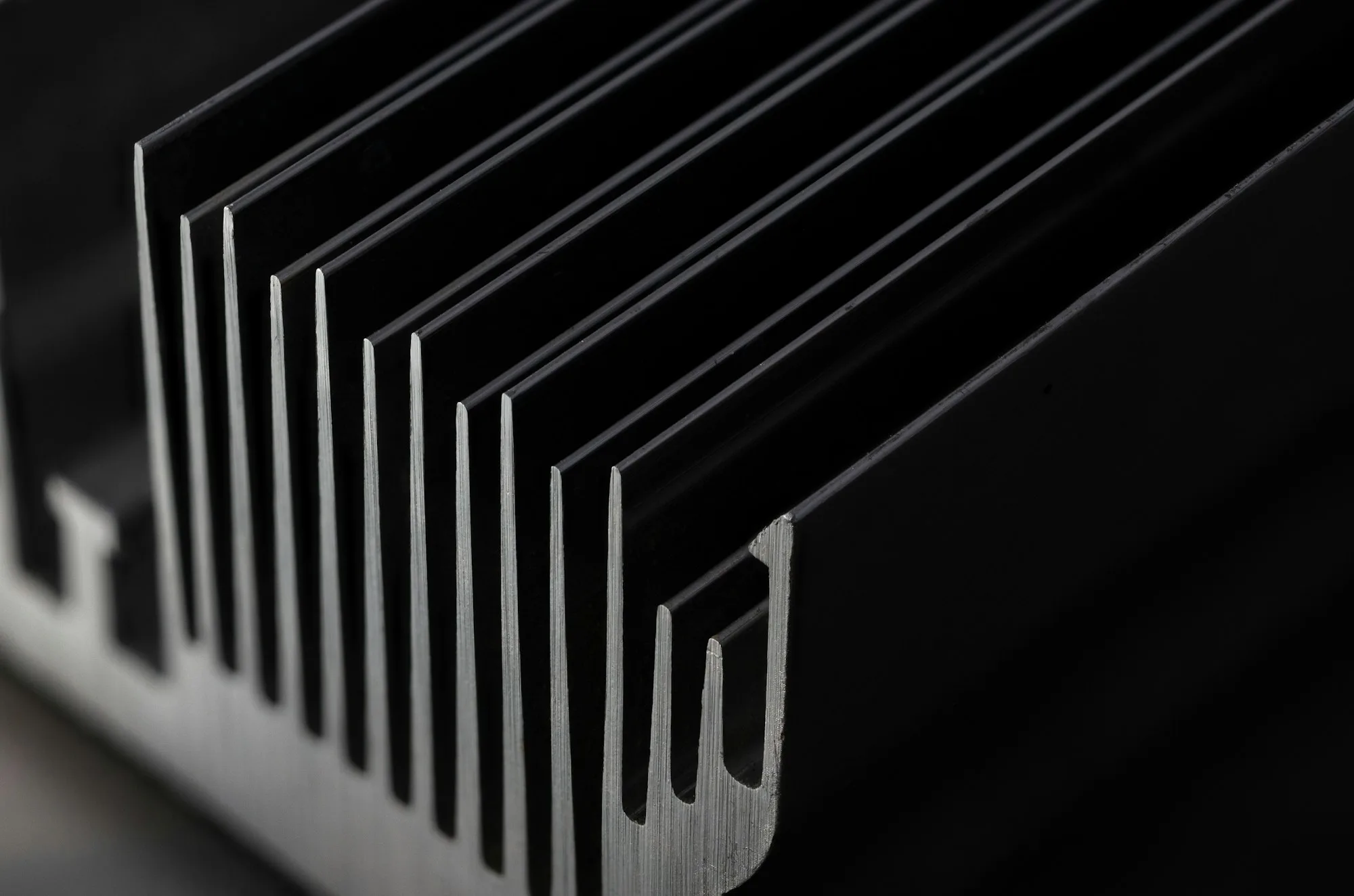 Close-up of parallel fins on a black anodized aluminum heatsink extrusion.