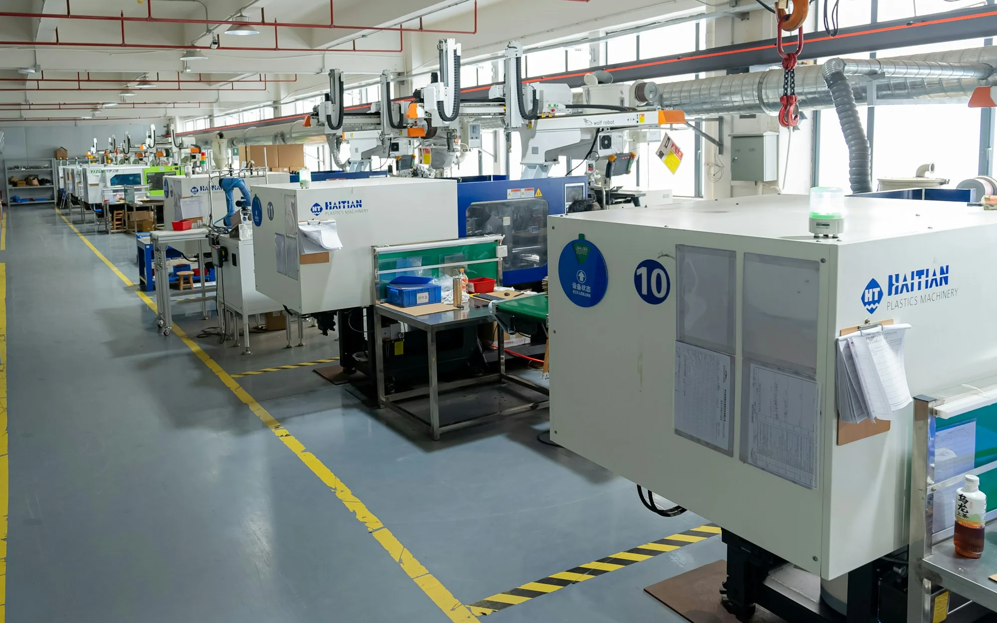 Row of automated injection molding machines operating in a plastics production facility.