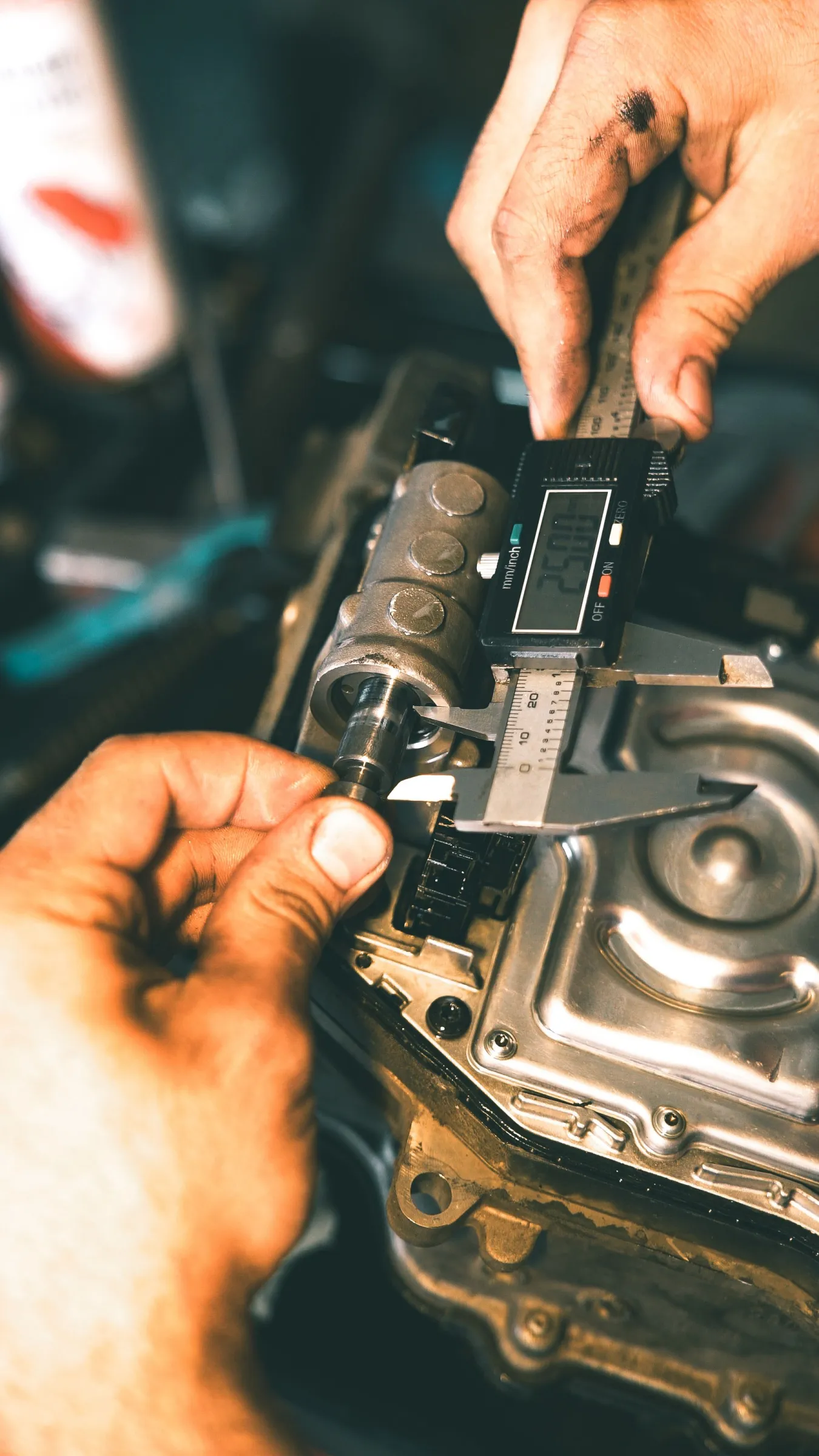 Technician using a digital caliper to inspect the diameter of a machined metal component.